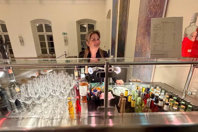 Die Catering-Bar bei Elysium Concerts mit Getränken und einer Mitarbeiterin hinter der Theke